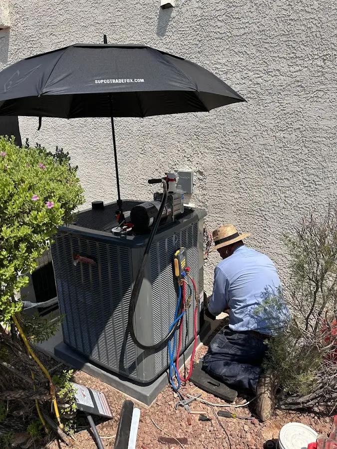 HVAC technician performing outdoor AC maintenance in Richland